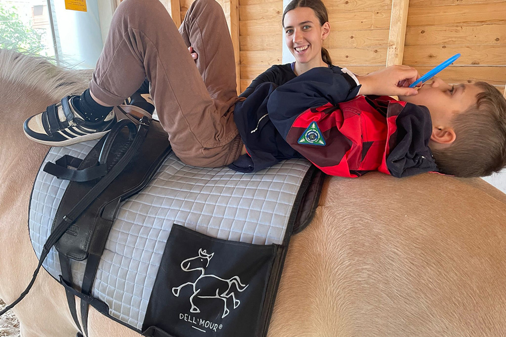 Kind liegt auf Pferderücken